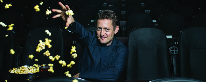 Alex Winter throwing popcorn in a theater
